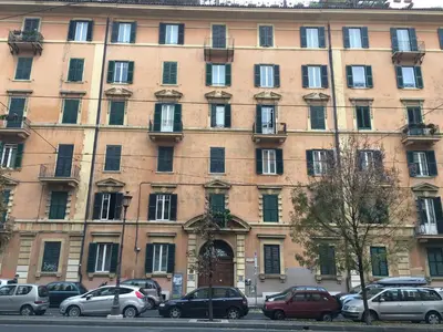 a large building with cars parked in front of it at Colosseo Holiday House in Rome
