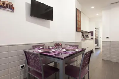 a kitchen with a table with chairs and a tv on the wall at Saint Peter Basilica 200m- 2BR -2BA -Sleeps 6 in Rome