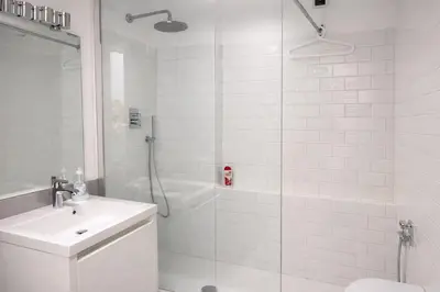 a white bathroom with a shower and a sink at Saint Peter Basilica 200m- 2BR -2BA -Sleeps 6 in Rome