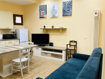 a living room with a blue couch and a kitchen at Villino Marcella in Rome