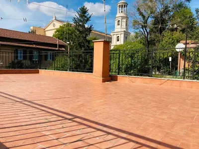 a brick patio in front of a building with a clock tower at Villino Marcella in Rome