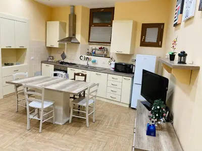 a kitchen with a table with chairs and a television at Villino Marcella in Rome