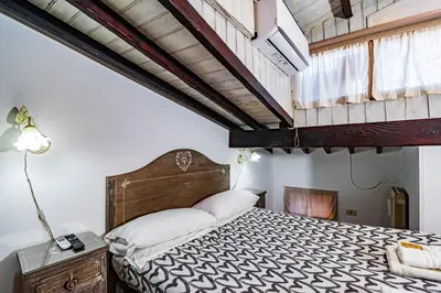 a bedroom with a large bed with a wooden headboard at Casa Trasteverina in Rome