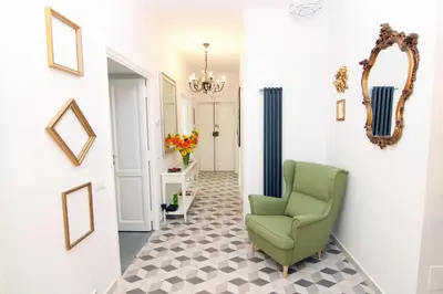 a hallway with a green chair and a mirror at Mio House Vatican in Rome