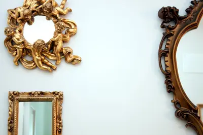 an ornate mirror and a mirror frame on a wall at Mio House Vatican in Rome