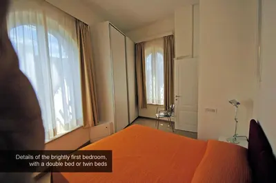 a bedroom with an orange bed and two windows at HISTORICAL CENTER ROME NAVONA AC 2 ROOMS HOLY DOOR VATICAN 5 MINUTES ON WALk in Rome