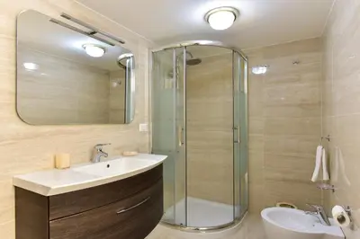 a bathroom with a shower and a sink and a mirror at Elite Rome Apartments in Rome