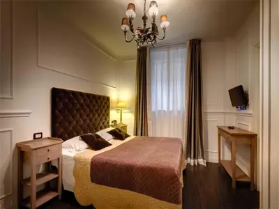 a bedroom with a large bed and a chandelier at The B Place in Rome