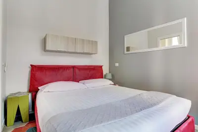 a bed with a red headboard in a room at Appartamento Santi Quattro - Colosseo in Rome