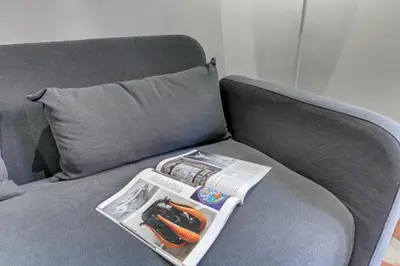 a gray couch with a tray with two hot dogs on it at Appartamento Santi Quattro - Colosseo in Rome