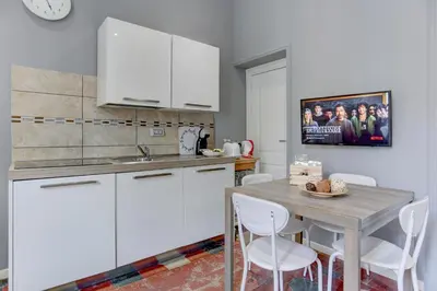 a kitchen with a table and white cabinets at Appartamento Santi Quattro - Colosseo in Rome
