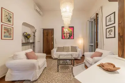 a living room with white furniture and a chandelier at Vatican Luxury Terrace in Rome