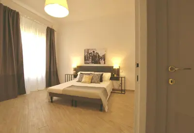 a bedroom with a bed and a large window at Domus in Laterano in Rome