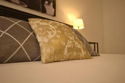 a bed with a pillow on it with a lamp at Domus in Laterano in Rome