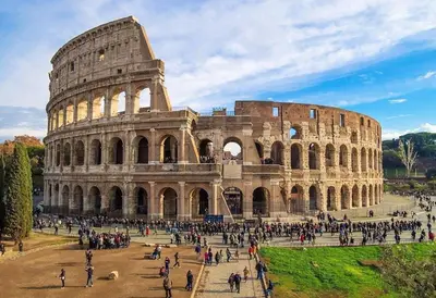 a group of people walking around the coliseum at Saint Peter House Germanico in Rome