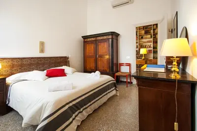 a bedroom with a bed and a desk with a lamp at Wanderlust - FromHometoRome in Rome
