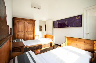 a room with four beds and a painting on the wall at Wanderlust - FromHometoRome in Rome