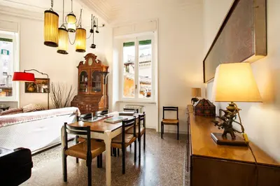 a living room with a table and chairs and a couch at Wanderlust - FromHometoRome in Rome