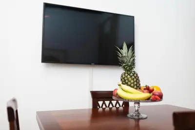a bowl of fruit on a table with a flat screen tv at Tritone 91 Apartments in Rome