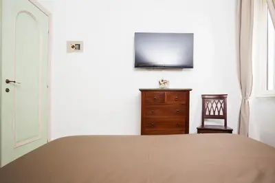 a bedroom with a bed and a dresser and a television at Tritone 91 Apartments in Rome