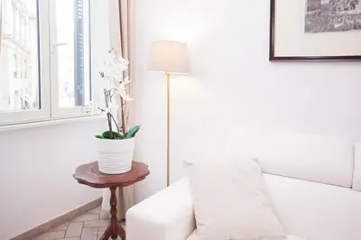 a living room with a white couch and a table with a lamp at Tritone 91 Apartments in Rome