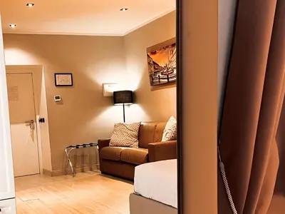 a living room with a couch and a mirror at Fabio Massimo Guest House in Rome