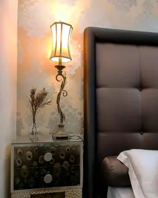 a lamp on a night stand next to a bed at Persia Collection Trevi in Rome