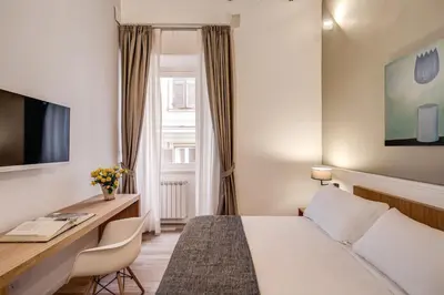 a hotel room with a bed and a desk at Dopodomani Suite in Rome