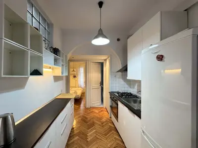 a kitchen with white cabinets and a black counter top at Vatican Charming Suite in Rome