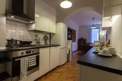 a kitchen with white cabinets and a stove top oven at Vatican Charming Suite in Rome