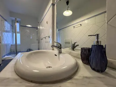 a white sink in a bathroom with a mirror at Vatican Charming Suite in Rome