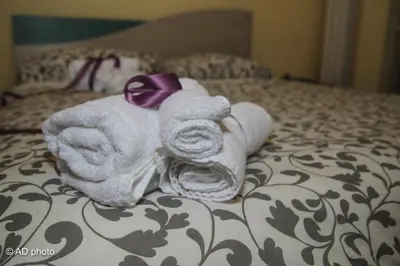 two towels on a bed with a purple bow at Homesuitehome in Rome