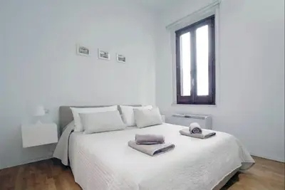 a white bedroom with a bed with two towels on it at Navona Secret Suite in Rome