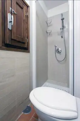a bathroom with a white toilet and a shower at Navona Secret Suite in Rome