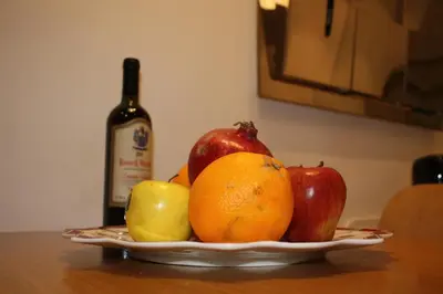 a plate of fruit on a table with a bottle of wine at Navona Secret Suite in Rome
