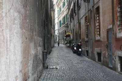 an alley with a motorcycle parked on the side of a building at Navona Secret Suite in Rome