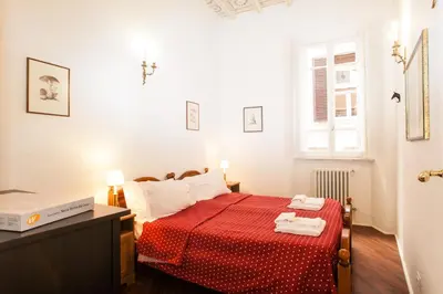 a bedroom with a bed with a red bedspread at Vicolo Torretta - FromHometoRome in Rome