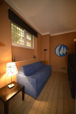a living room with a blue couch and a table at Bed&BikeRome Suite in Rome