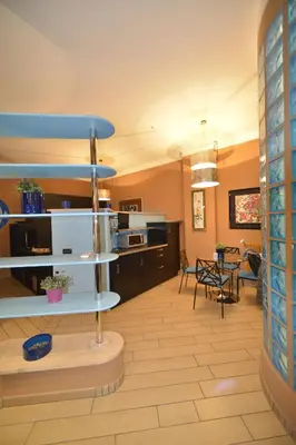 a kitchen and living room with blue shelves at Bed&BikeRome Suite in Rome