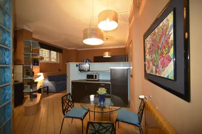 a living room with a table and chairs and a kitchen at Bed&BikeRome Suite in Rome