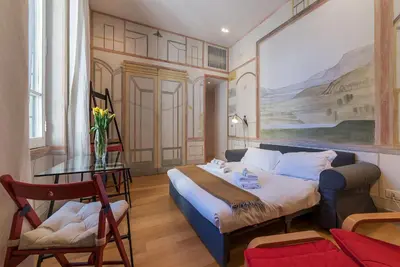 a bedroom with a bed and a painting on the wall at Domus Claudiae - FromHometoRome in Rome