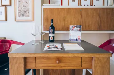 a table with a bottle of wine and two glasses at Restart Accommodations Farnesina in Rome