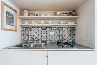 a kitchen with a sink and a tile wall at Restart Accommodations Farnesina in Rome