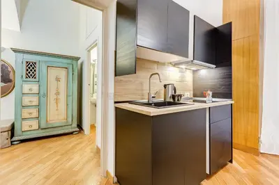 a kitchen with black cabinets and a sink at VENETO COMFORTABLE Apartment in Rome