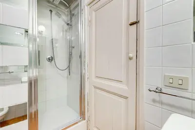 a bathroom with a shower and a white door at VENETO COMFORTABLE Apartment in Rome