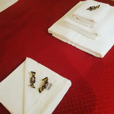 two small figurines on a napkin next to towels at VENETO COMFORTABLE Apartment in Rome