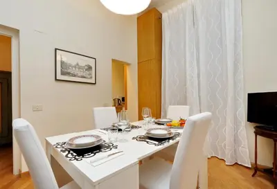 a white dining room with a white table and chairs at VENETO COMFORTABLE Apartment in Rome