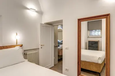 a bedroom with two beds and a mirror at Casa Alessandra in Rome