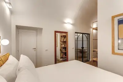 a bedroom with a white bed and a mirror at Casa Alessandra in Rome