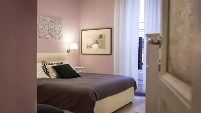 a bedroom with a bed in a room with pink walls at Rental in Rome Otranto Relax in Rome